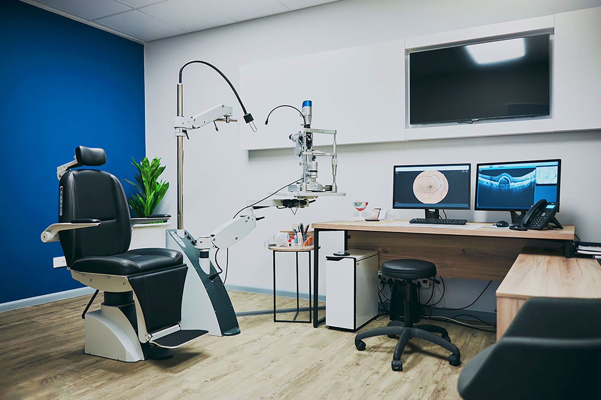 Modern ophthalmology examination room with slit lamp and retina imaging system.