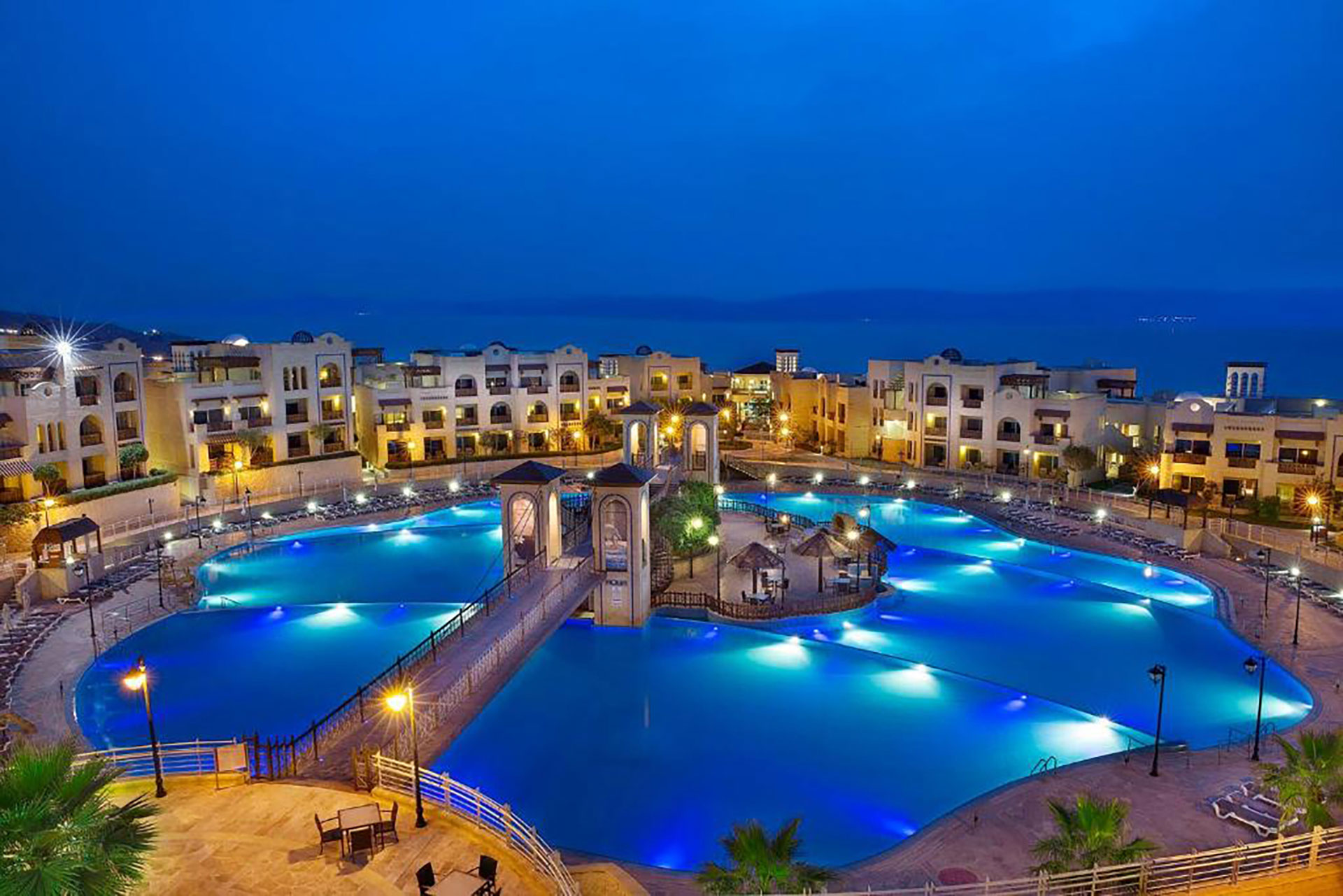 Night view of Dead Sea resort with illuminated swimming pool in Jordan.