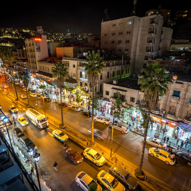 Night view of downtown Amman, Jordan, with busy streets, shops, and vibrant nightlife.