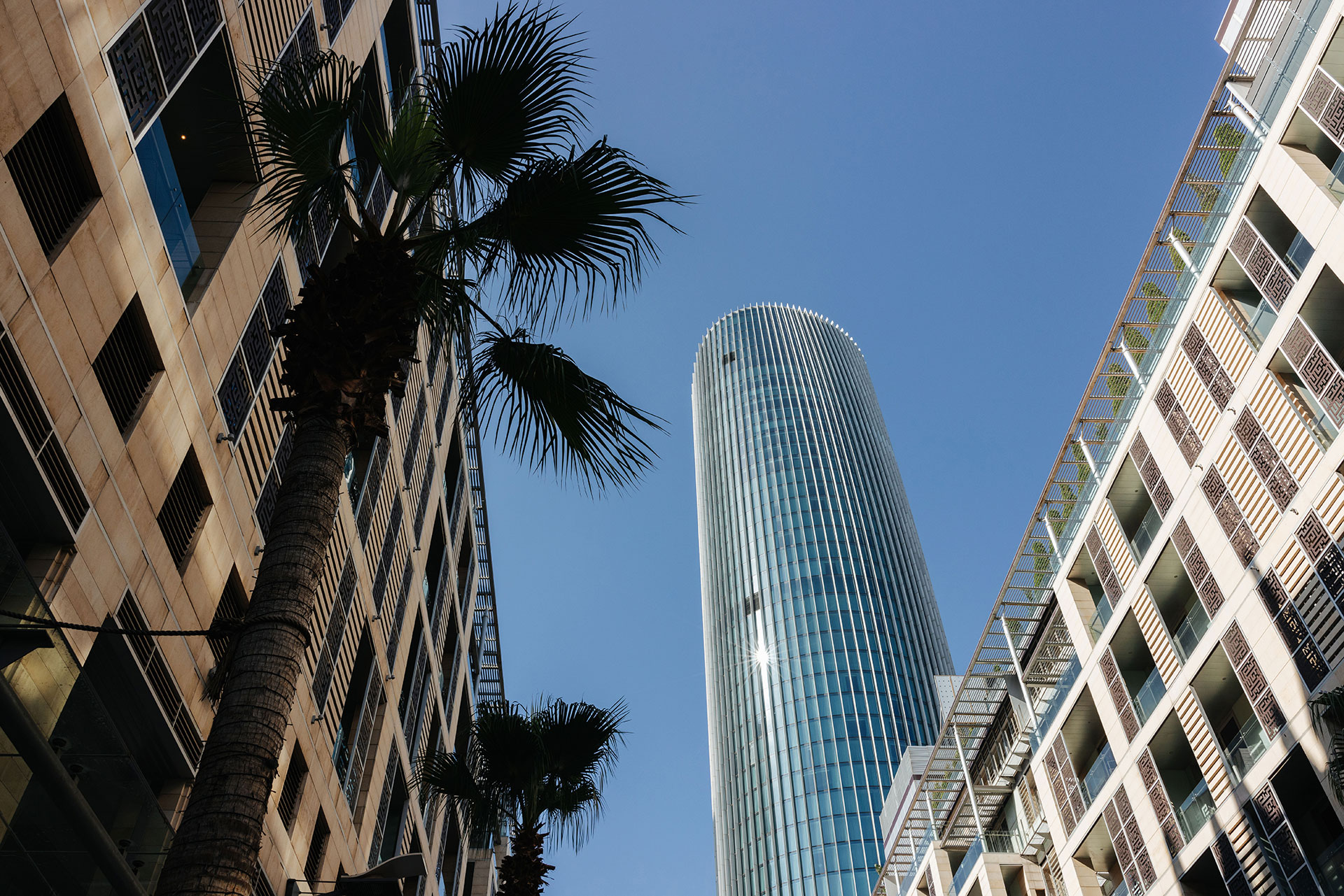 Abdali Tower at The Boulevard in Amman, Jordan with palm trees and modern buildings.