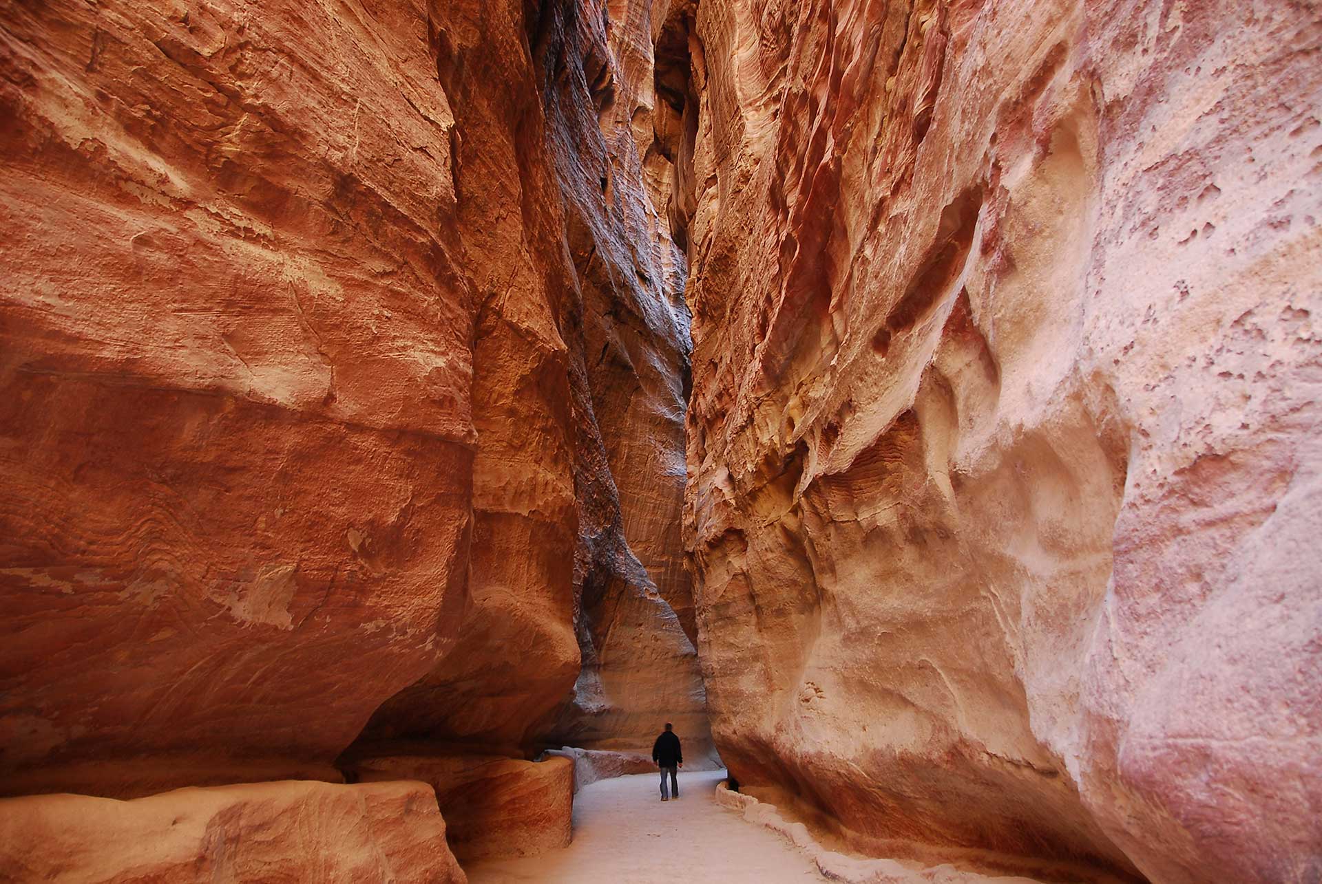 The Siq canyon entrance to Petra in Jordan, a narrow gorge with towering sandstone cliffs.