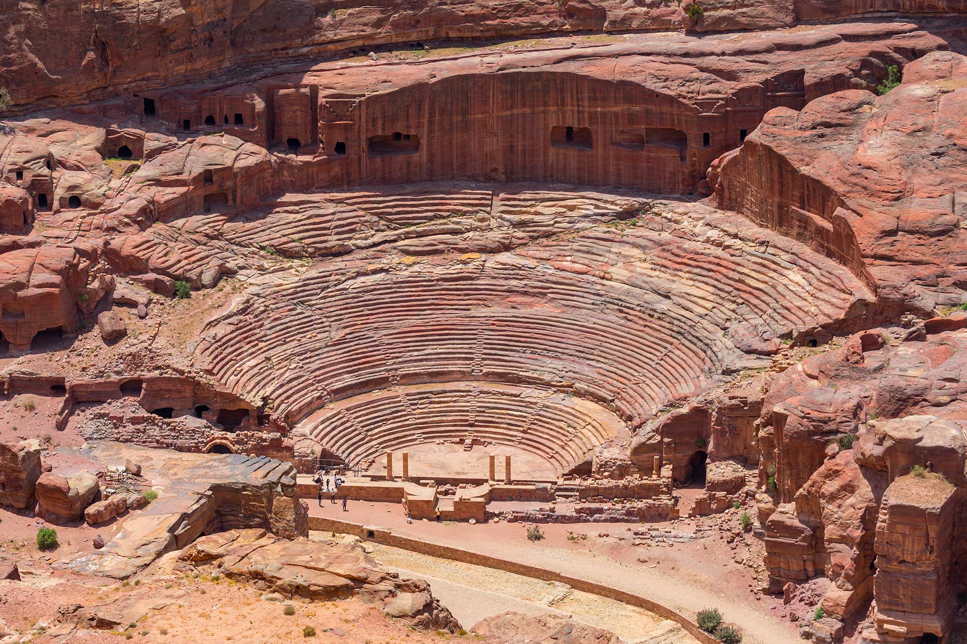 The Nabatean Theatre in Petra, Jordan – an ancient amphitheatre carved into red sandstone cliffs.